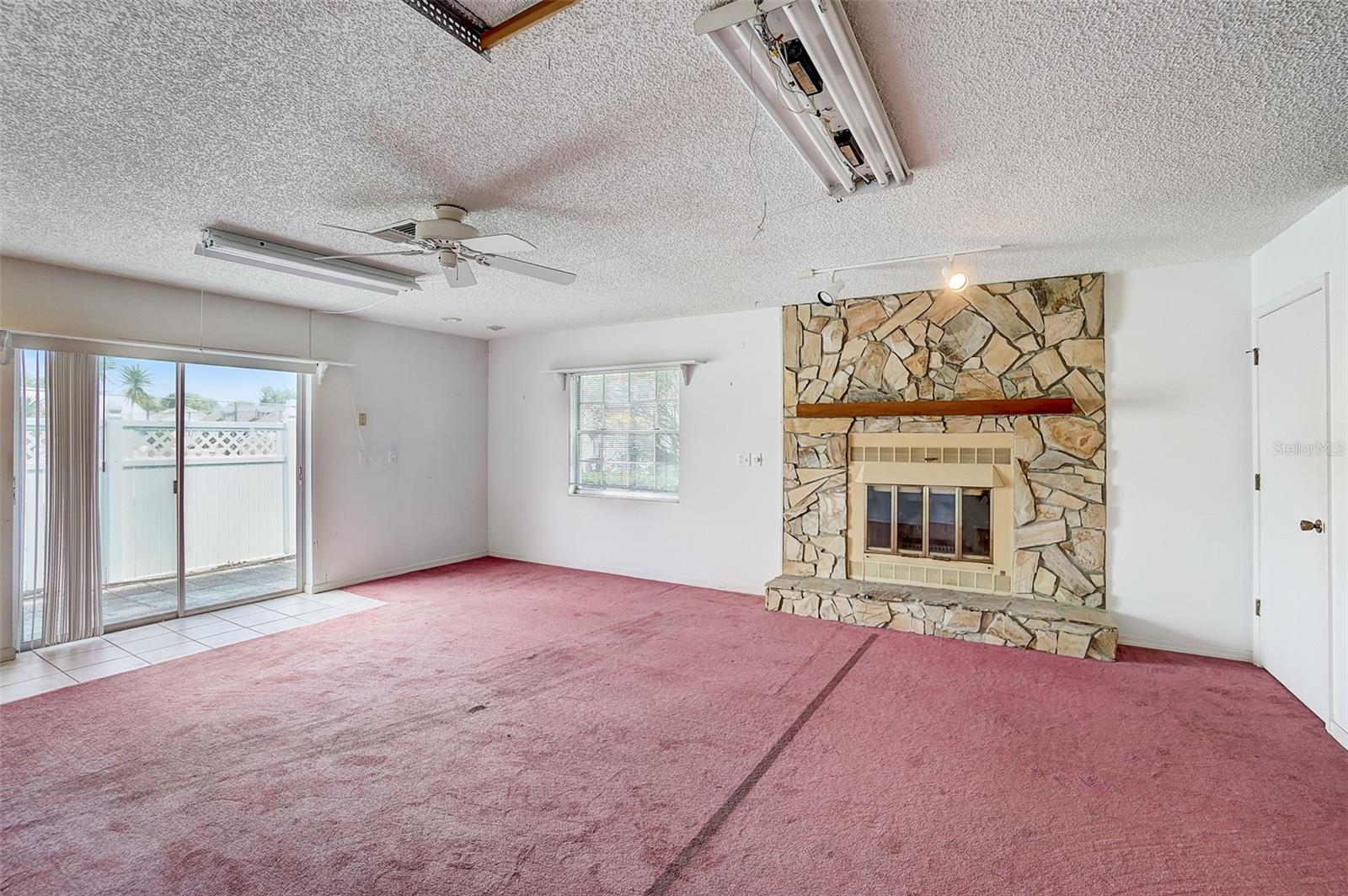 First Floor spacious living room with cozy fireplace, sliders out to the patio, and a convenient laundry room.