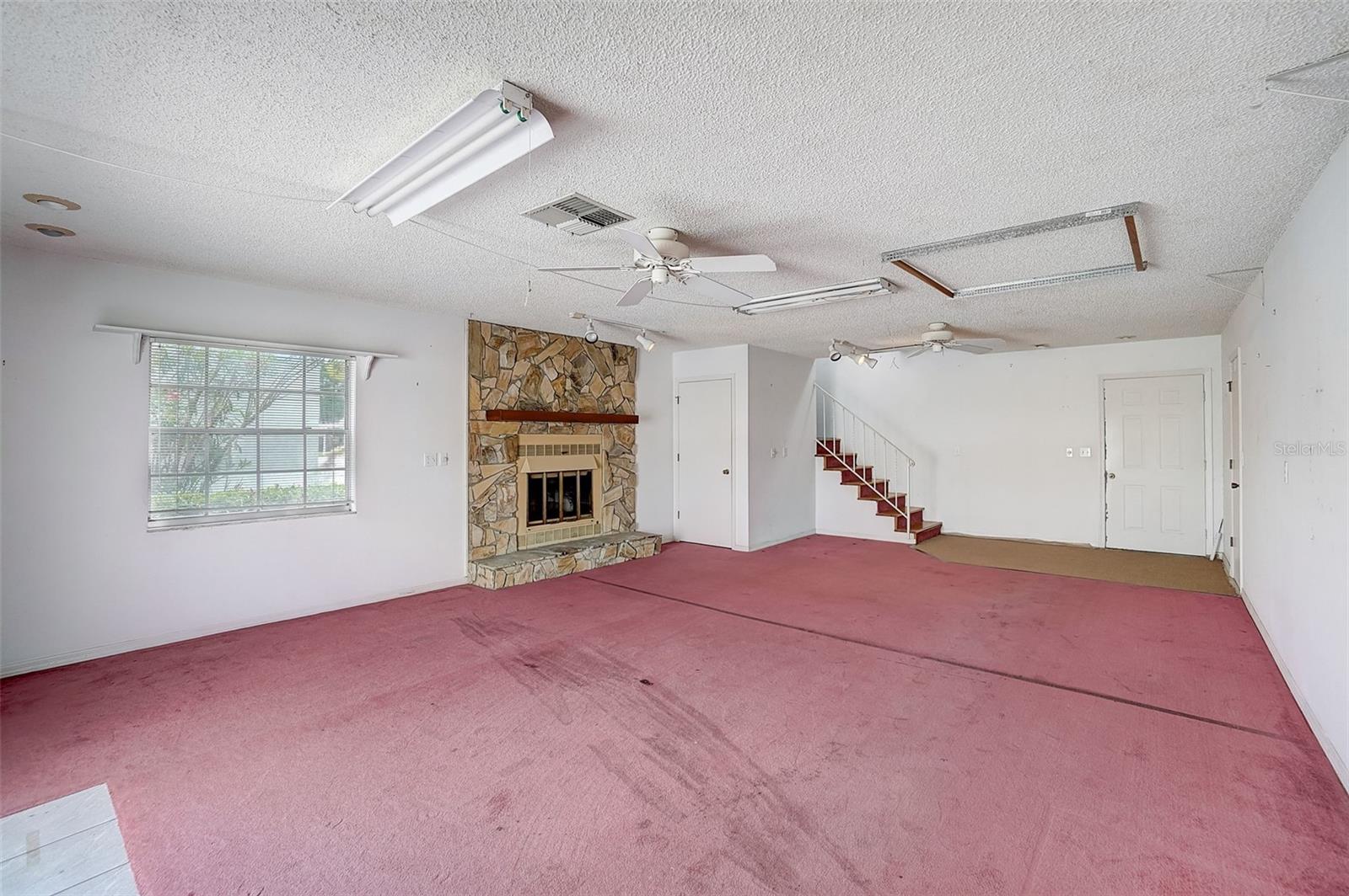 First Floor spacious living room with cozy fireplace, sliders out to the patio, and a convenient laundry room.