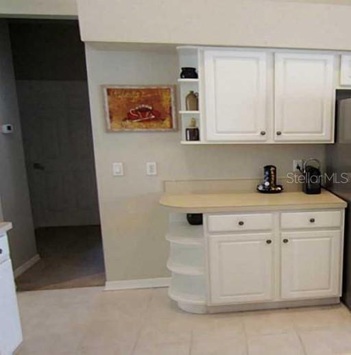 Stainless steel appliances and ceramic tile floors are in the kitchen