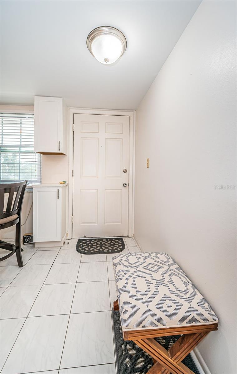 Extra cabinets next to the entrance with newer tile flooring in the kitchen!