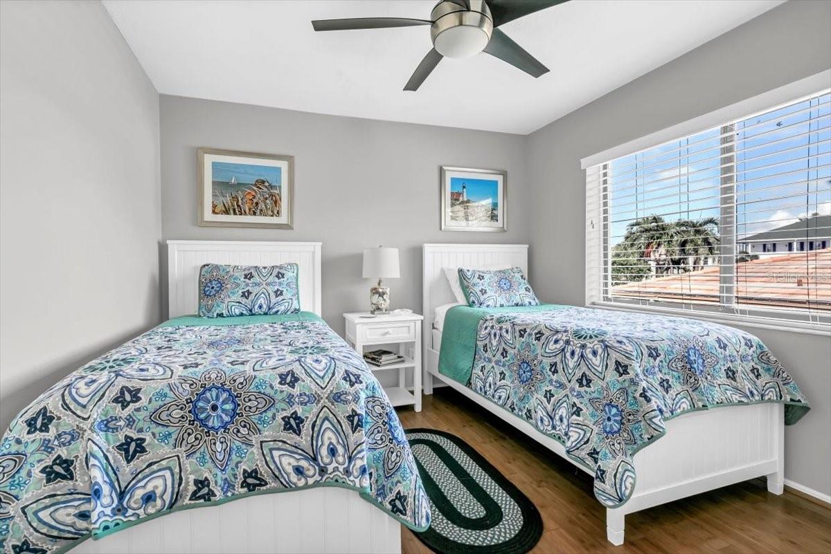 The second bedroom has a large window with natural light cascading through.