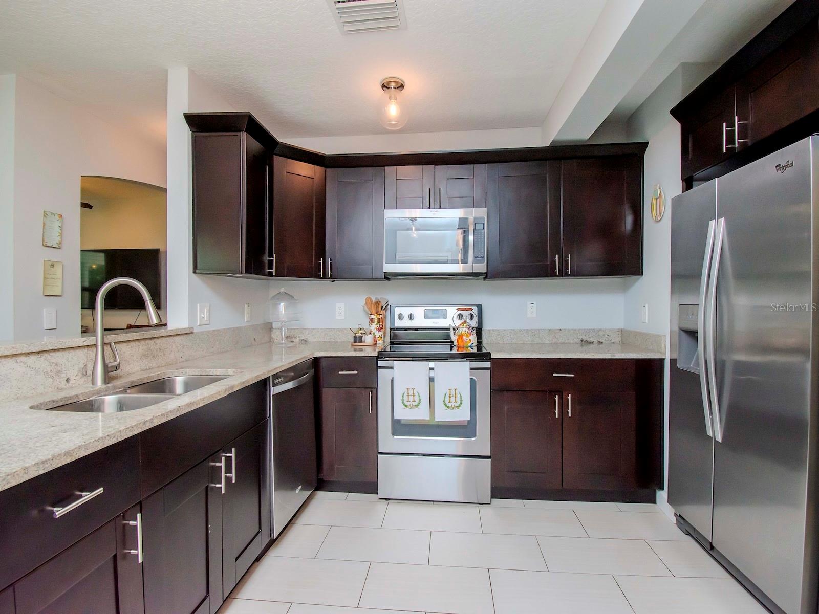 Functional kitchen with lots of counter space and stainless steel appliances.