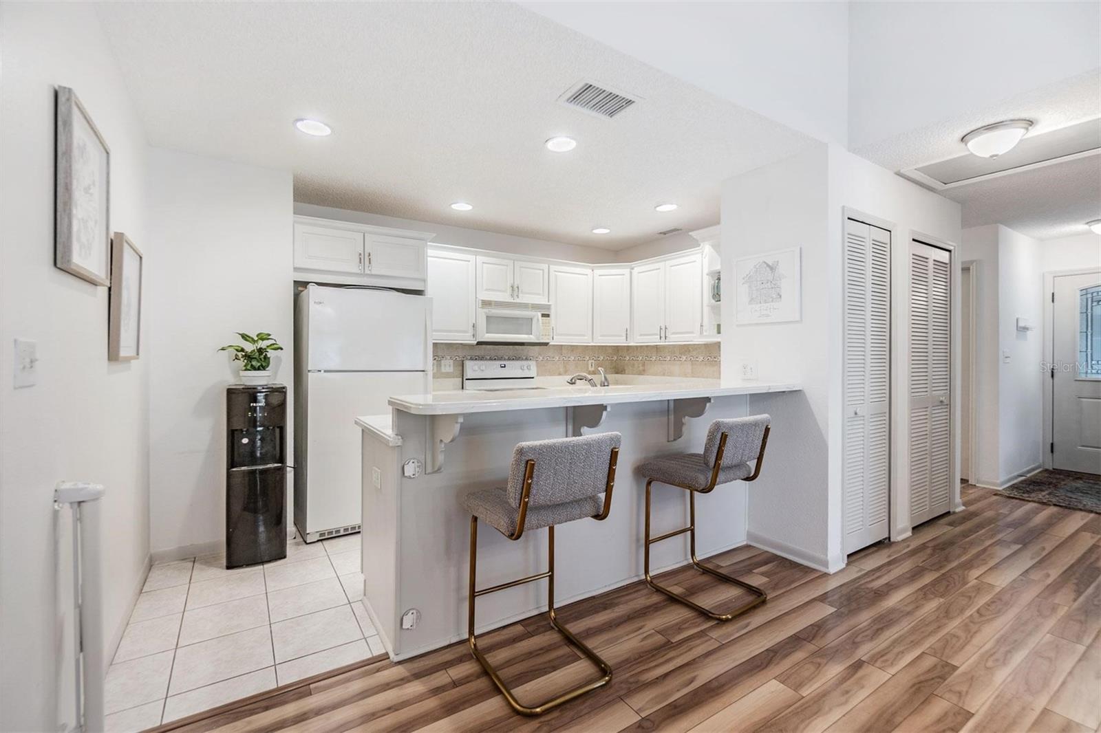 Kitchen is light and bright with extended elevated countertop for pull up seating.