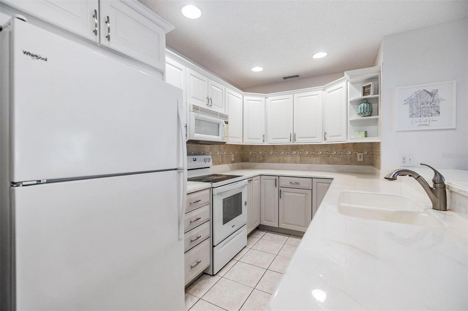 Kitchen is light and bright with extended elevated countertop for pull up seating.