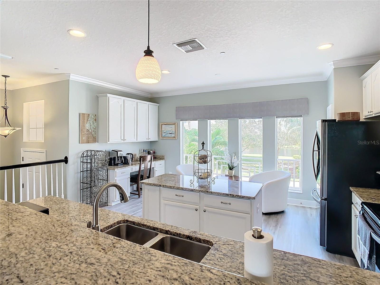 Nice view of the spacious kitchen that shows the desk area, all the counter space and center island