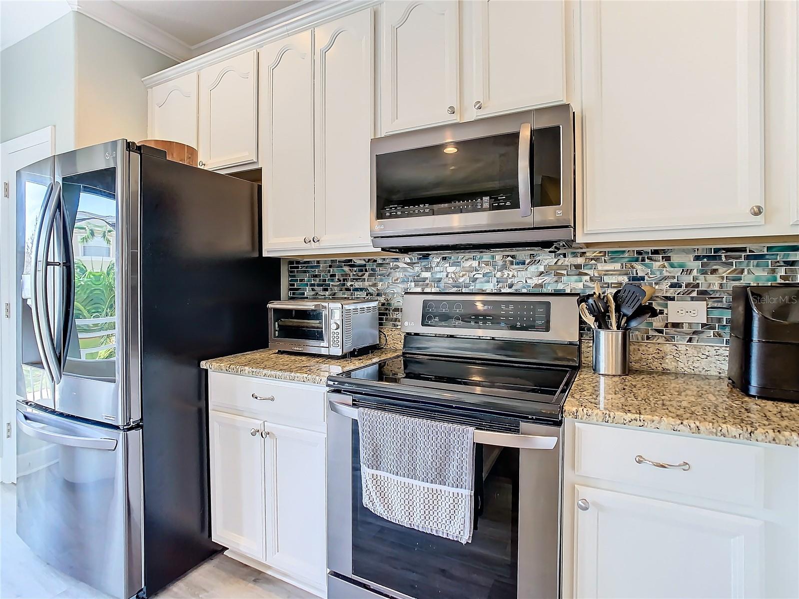 Stainless steel appliances and beautiful backsplash in the kitchen