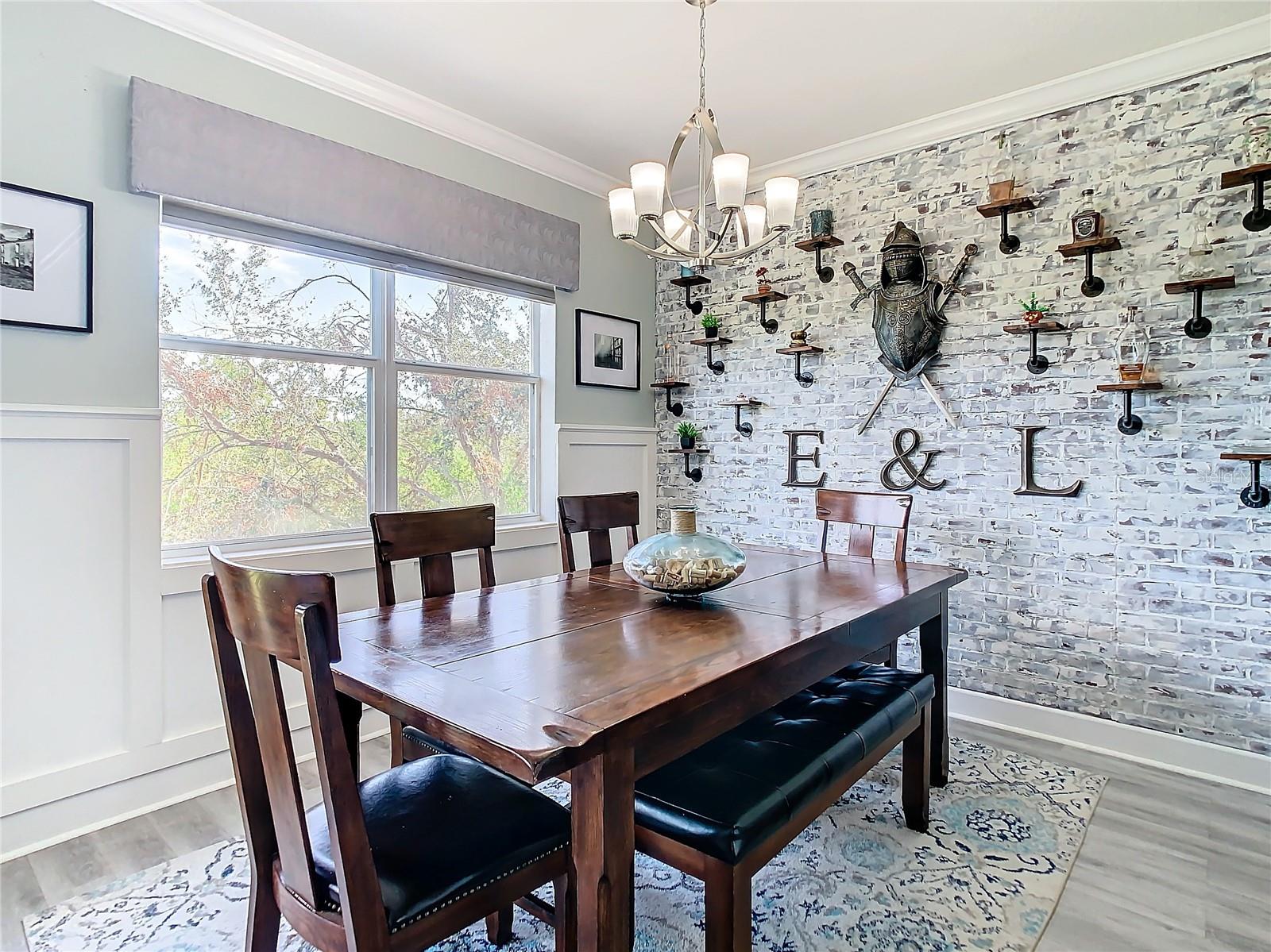 Dining room with a faux brick wall.  The faux brick can easily be removed.  Notice the nice view out the dining room windows