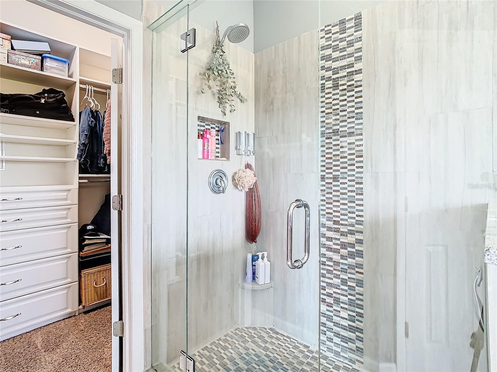 Closer look at the shower and walk in closet in the primary bathroom