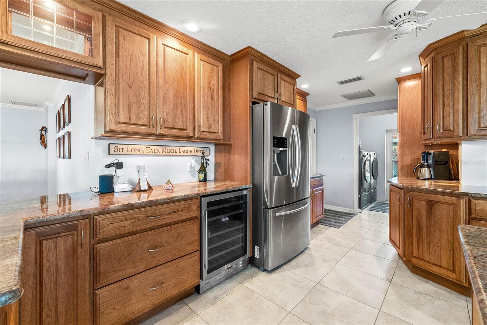 View of kitchen and separate laundry room photo from March 2024. Note: Wine refrigerator is no longer present.