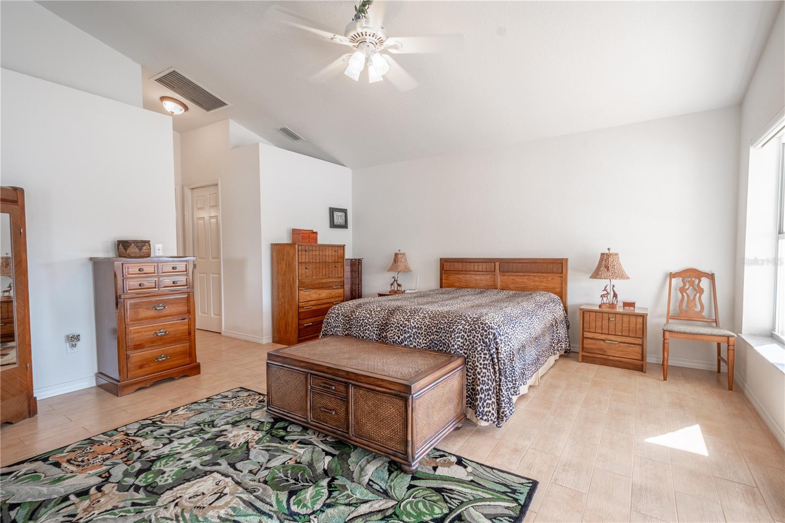 The Primary bedroom features a high ceiling, a ceiling fan with light kit and an ensuite bath.