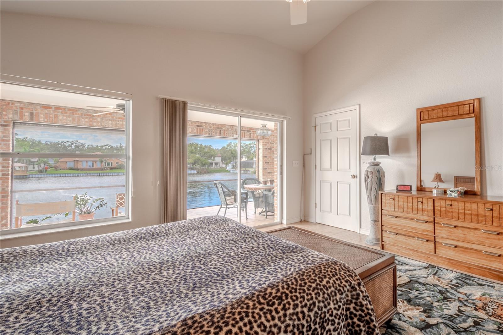 The primary bedroom features lake views with sliding glass doors to the lanai.