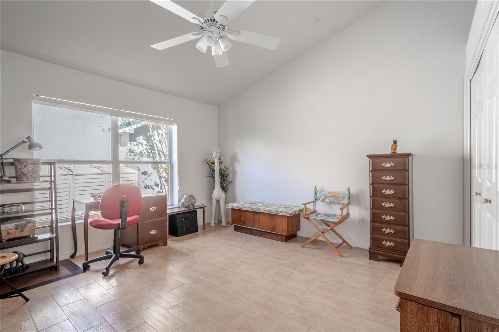 The 4th bedroom features neutral tones, ceramic tile flooring, a ceiling fan with light kit, and a built-in closet.