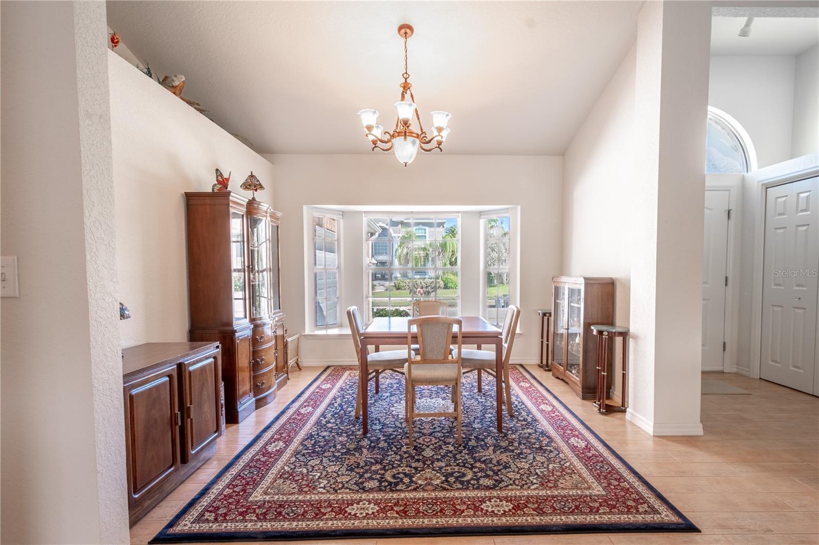 The dining room has a neutral color palate and ceramic tile flooring.