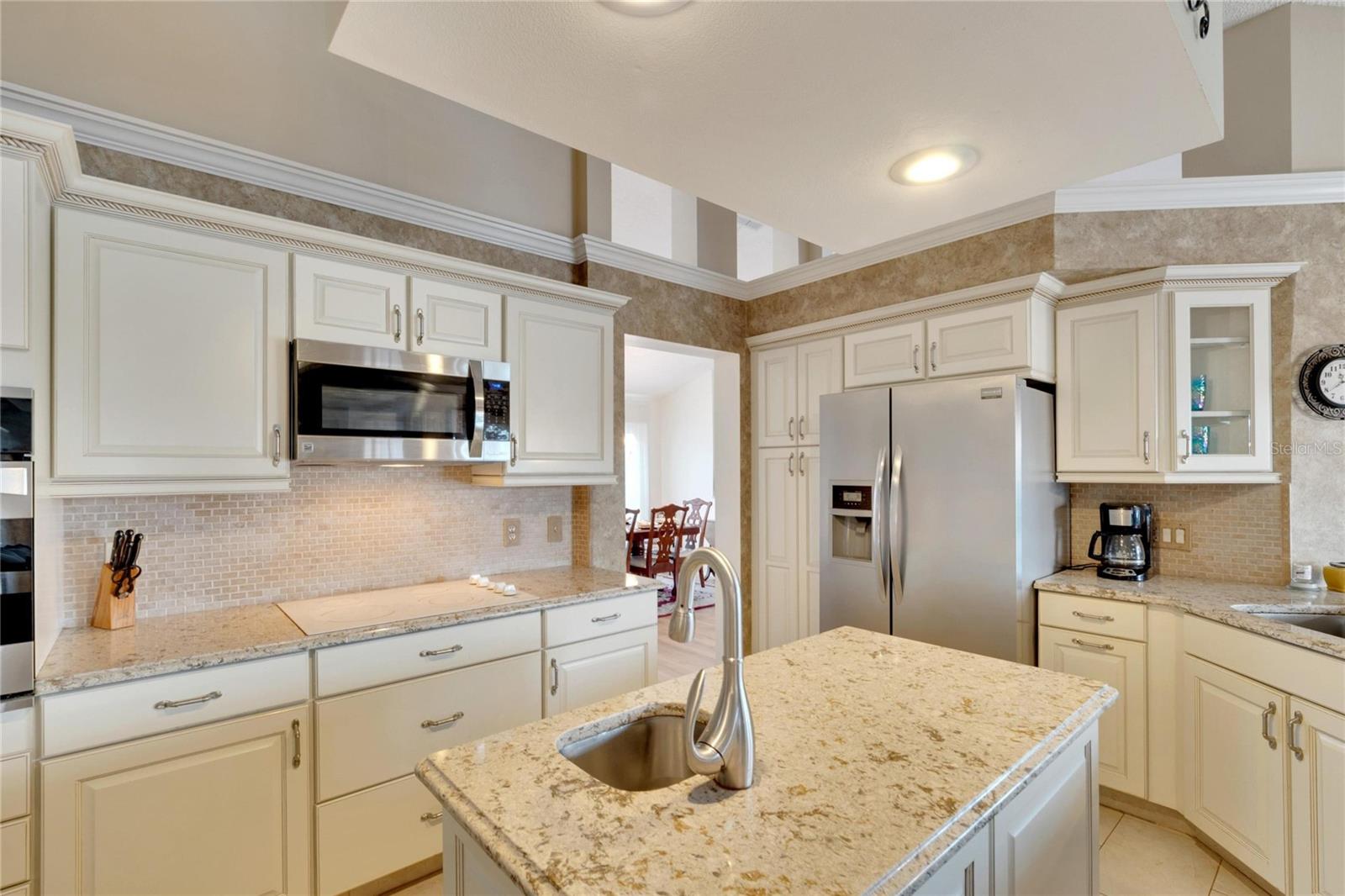 What a beautiful kitchen. The heart of the home has been recently been update.  Plenty of work surface and cabinetry.  Many of the cabinets have pull out sliding shelves for easy access.  Center island is perfect for all culinary projects.  Granite counters and handy prep sink.