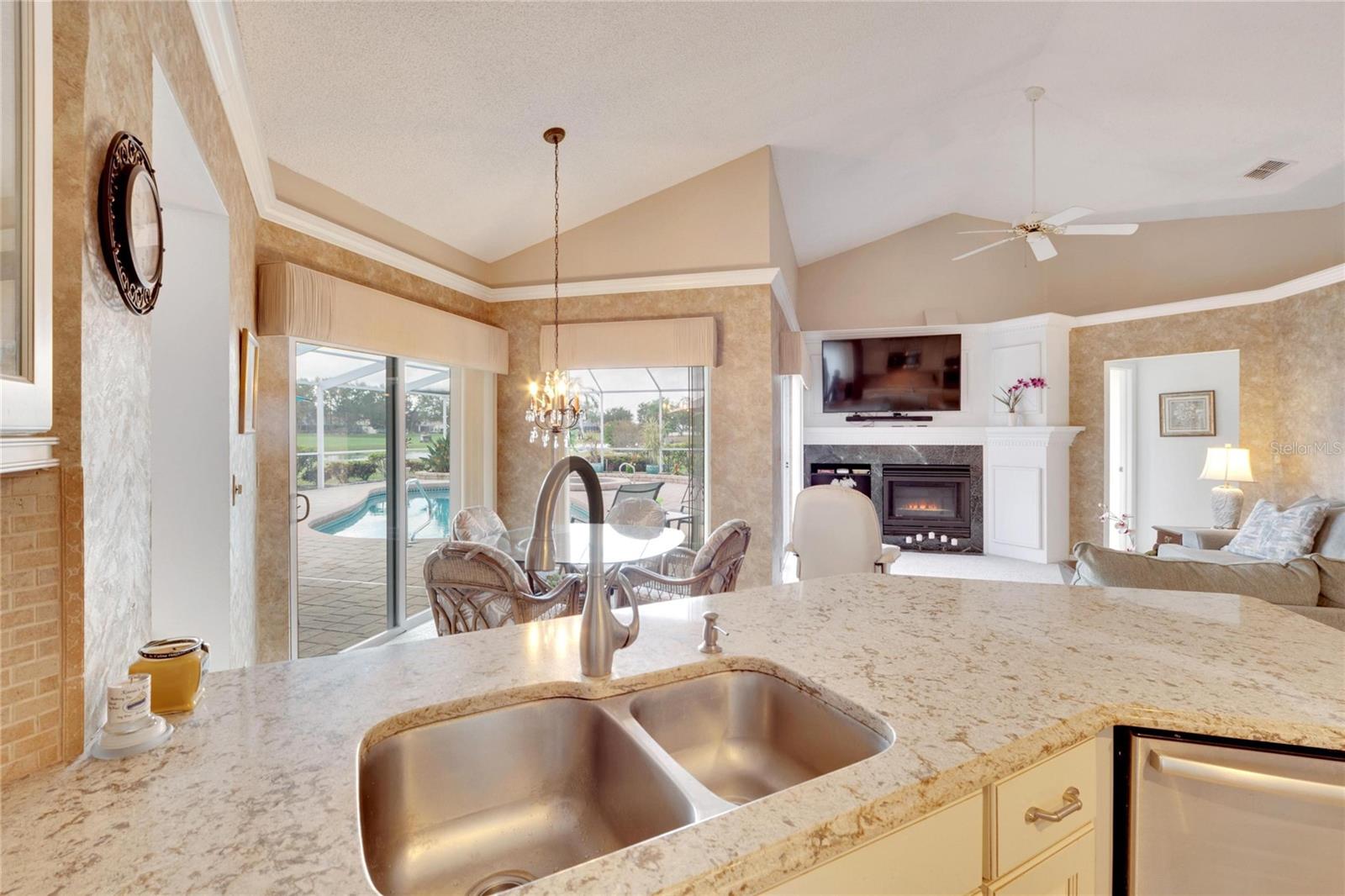 View from the kitchen sink into the family room overlooking the pool and lanai.