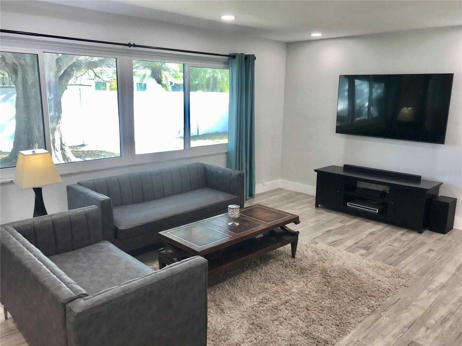 Living Area with large windows and recessed lighting. The floors throughout are easy care vinyl plank.