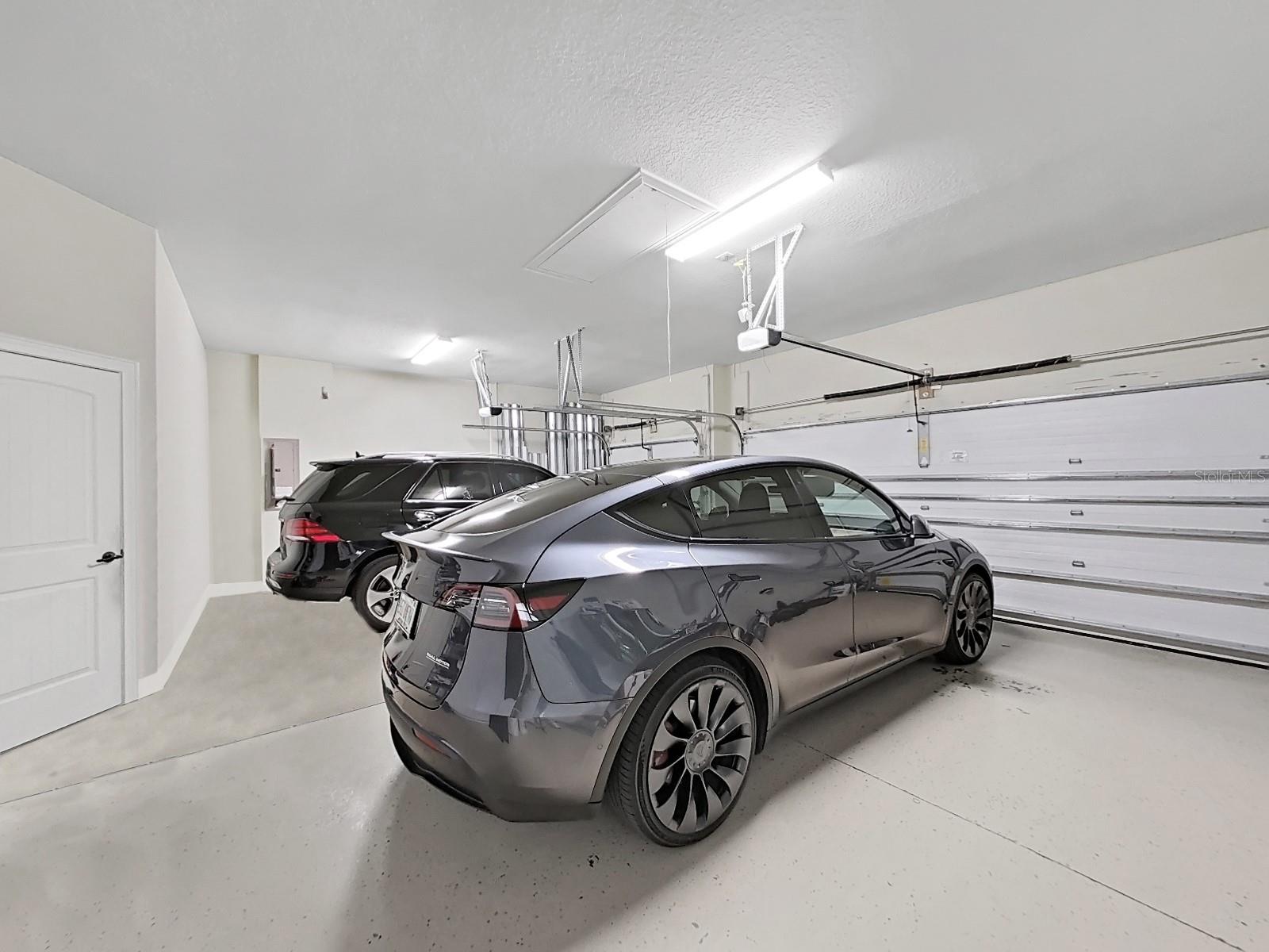 3-Car Garage with Epoxy Floor.  Other belongs in the garage had been removed from the photo during editting.  It has it's own entry door from the side.