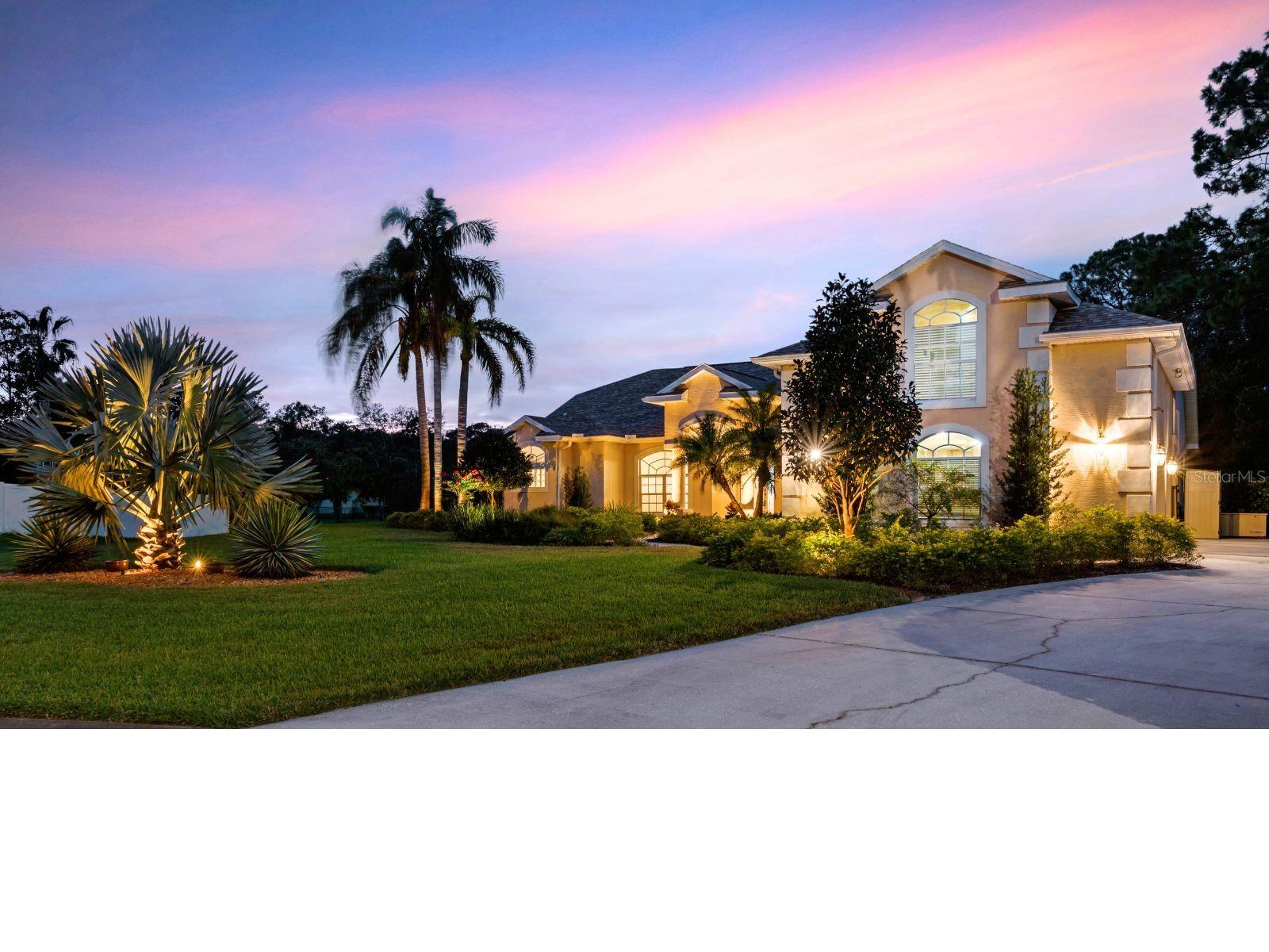 LED lighting highlights the lush landscaping and custom architecture.