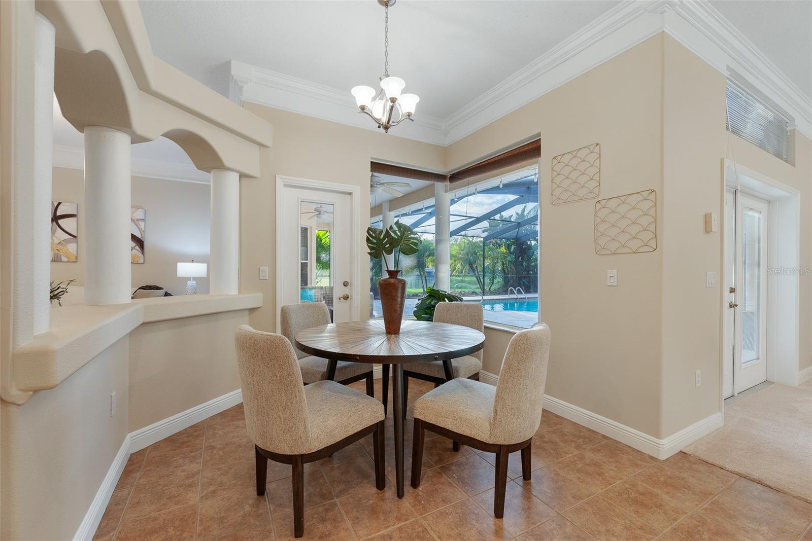 The adjacent breakfast nook opens to the pool area and covered entertaining patio, offering easy access to outdoor living.