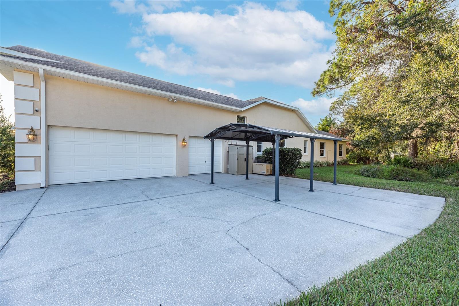 There is a car port outside of the garage that has a UV protecting roof to protect your car's paint.  Beyond the carport is a full house generator and a small storage shed that both convey to the buyer.