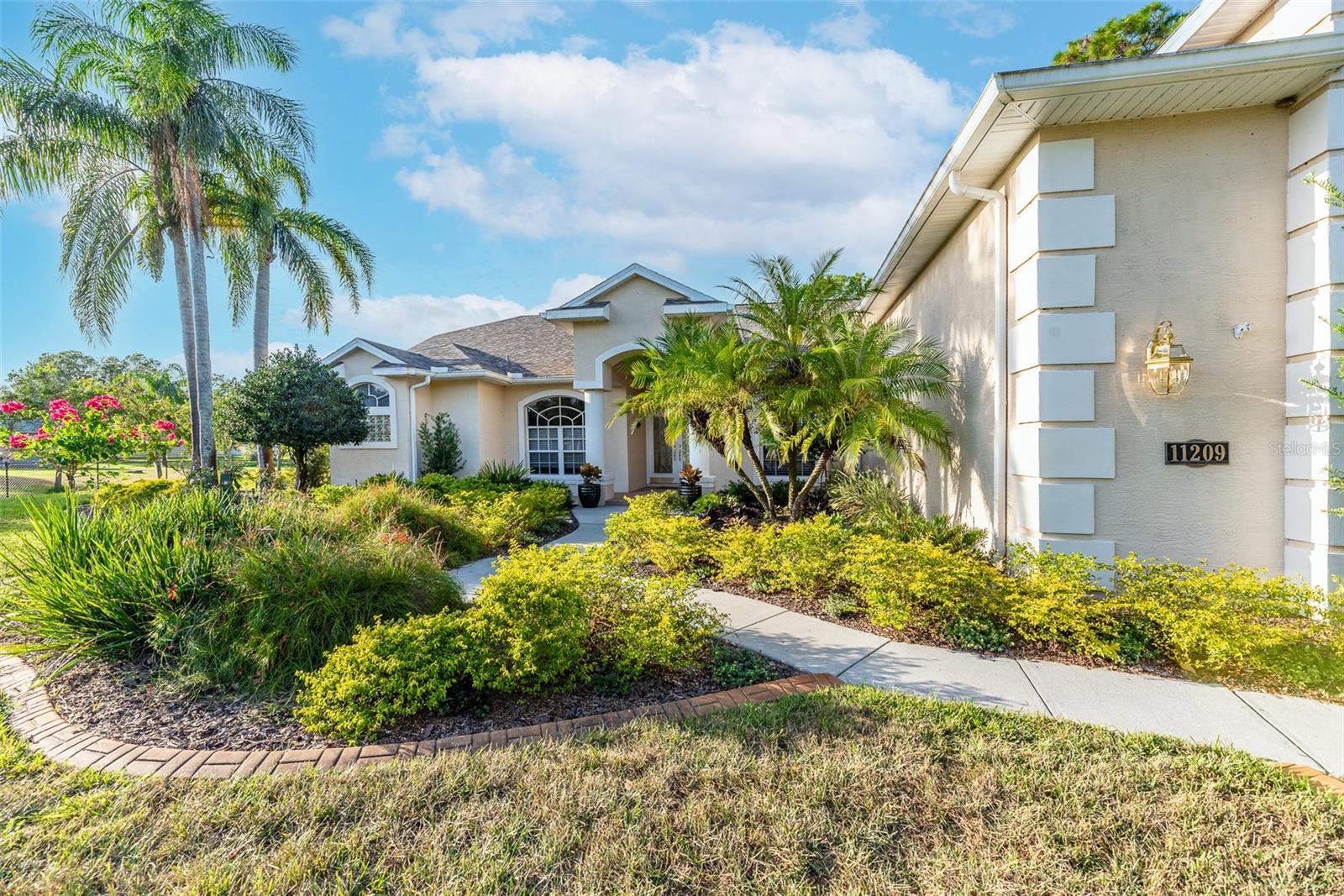 Stroll along a beautifully landscaped walkway with decorative concrete curbing.