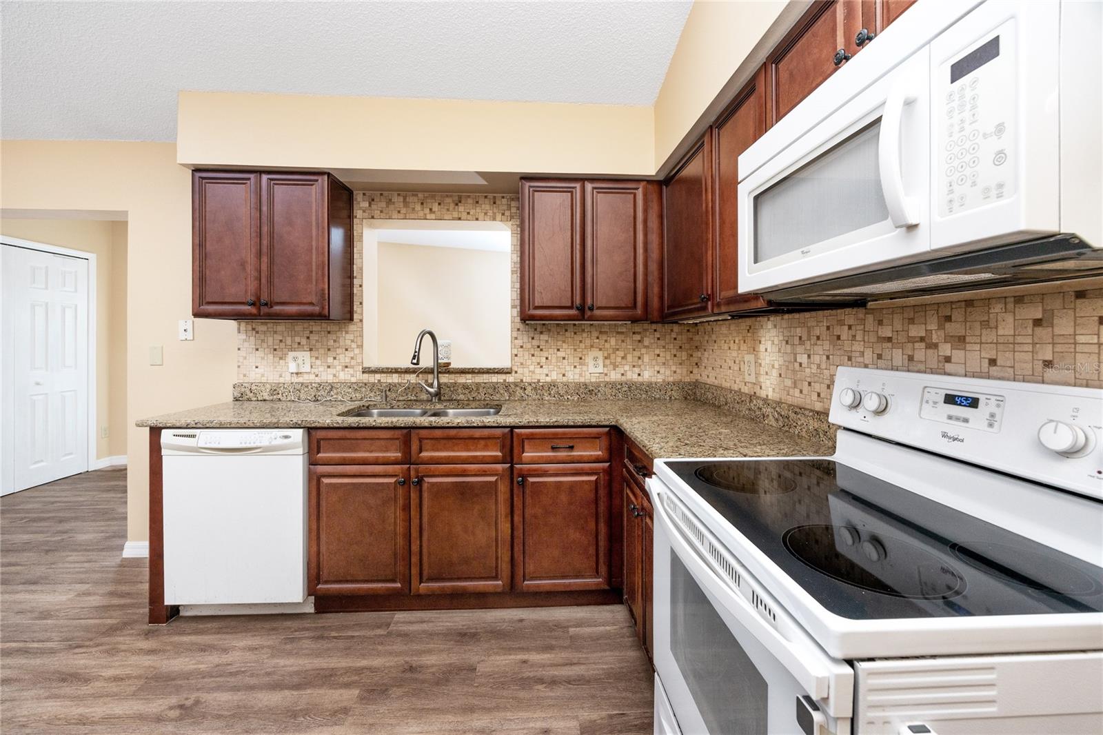 Updated kitchen with granite countertops and upgraded backsplash.