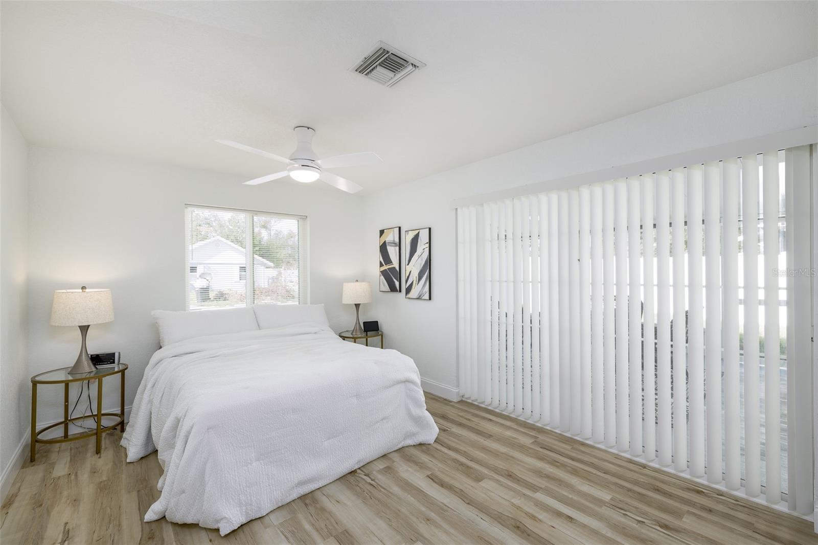 Primary bedroom with sliding doors opening to screened in porch