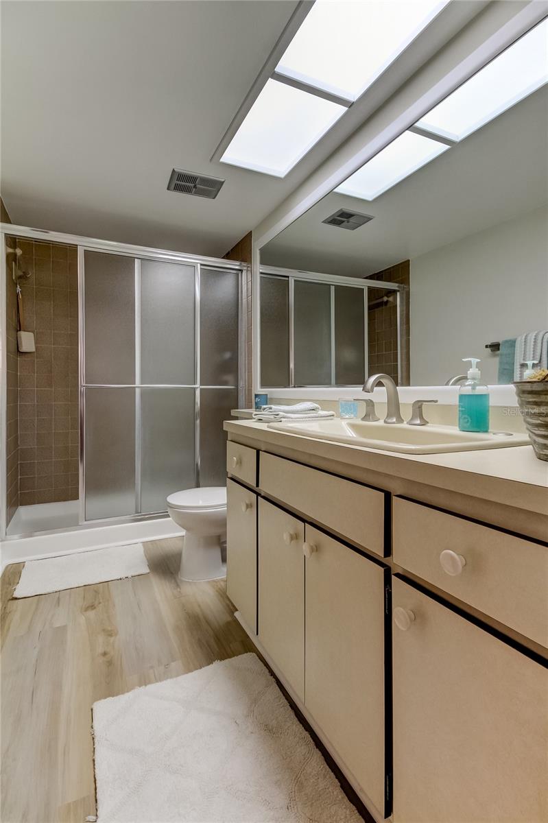 Owner's Retreat Bathroom.. offers extra counter space, walk in shower w/ sliding glass doors, Brand New Faucet & Luxury Vinyl Flooring just installed!