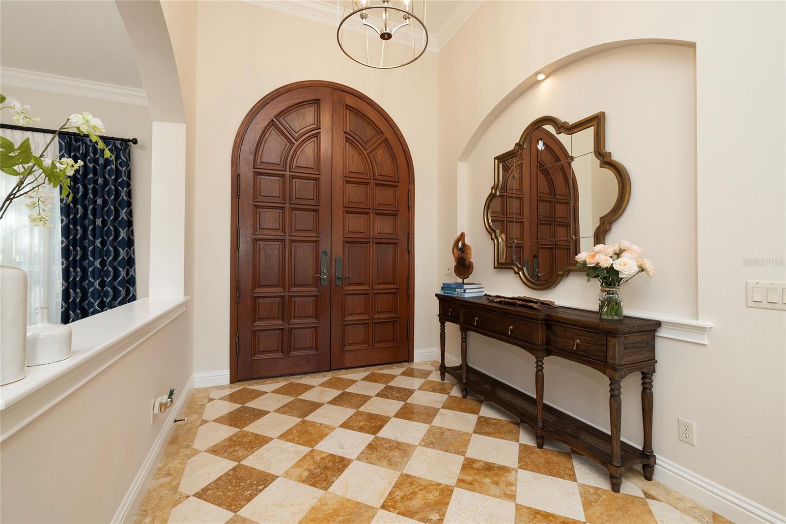 The 10 foot wood entry doors open to the foyer with a direct line of view to the living room and overlooks the dining room.