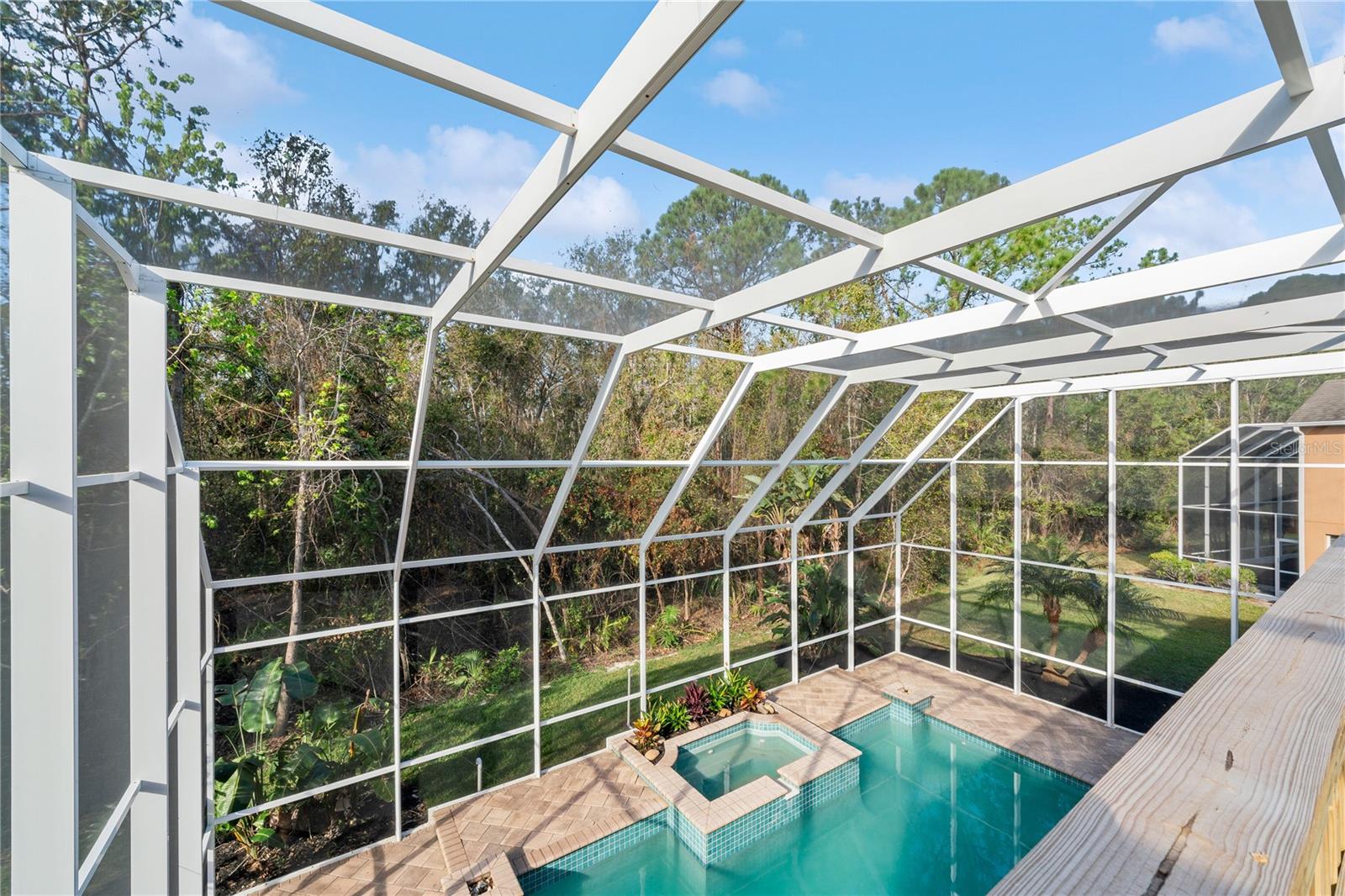 Balcony view of peaceful conservation and tranquil pool.