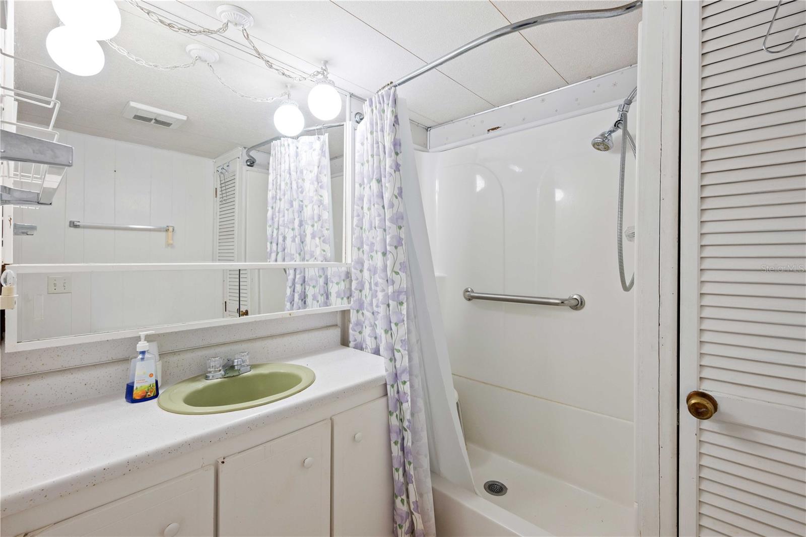 Main bathroom has step-in shower, plenty of storage, and high toilet.