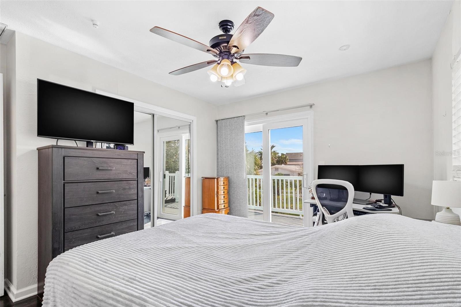 Primary bedroom w/ pool view and sliding door