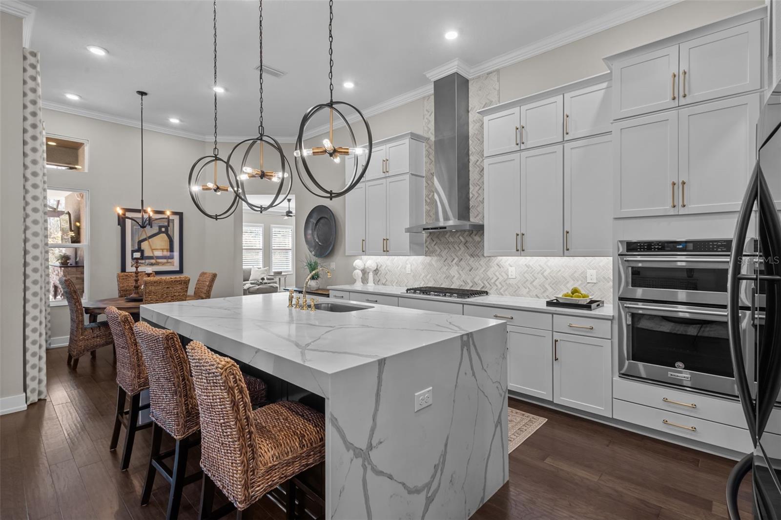 Kitchen - waterfall, quartz island, stacked cabinets, built in stainless steel appliances