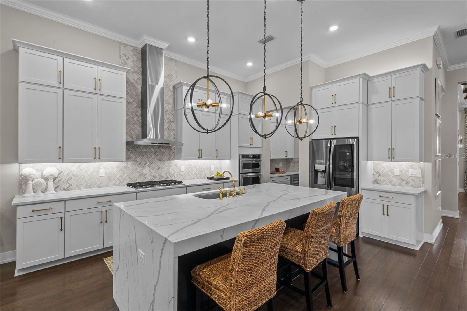 Kitchen - waterfall, quartz island, stacked cabinets, built in stainless steel appliances