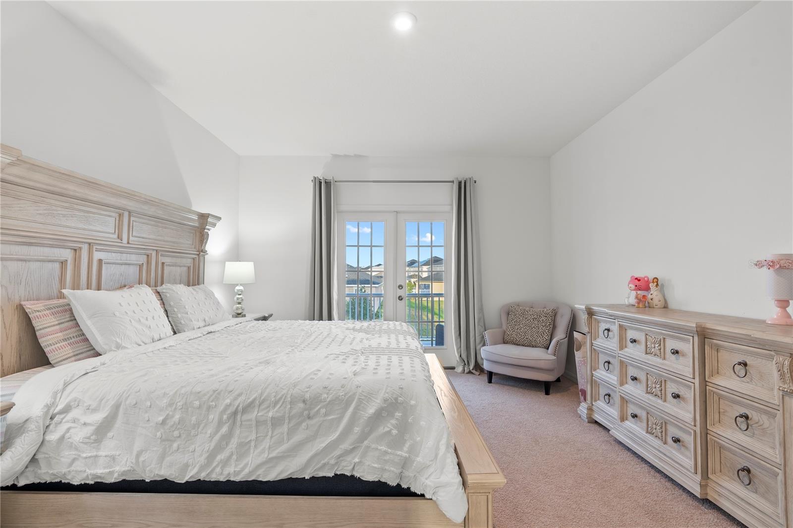 Master bedroom with doors leading to the balcony.