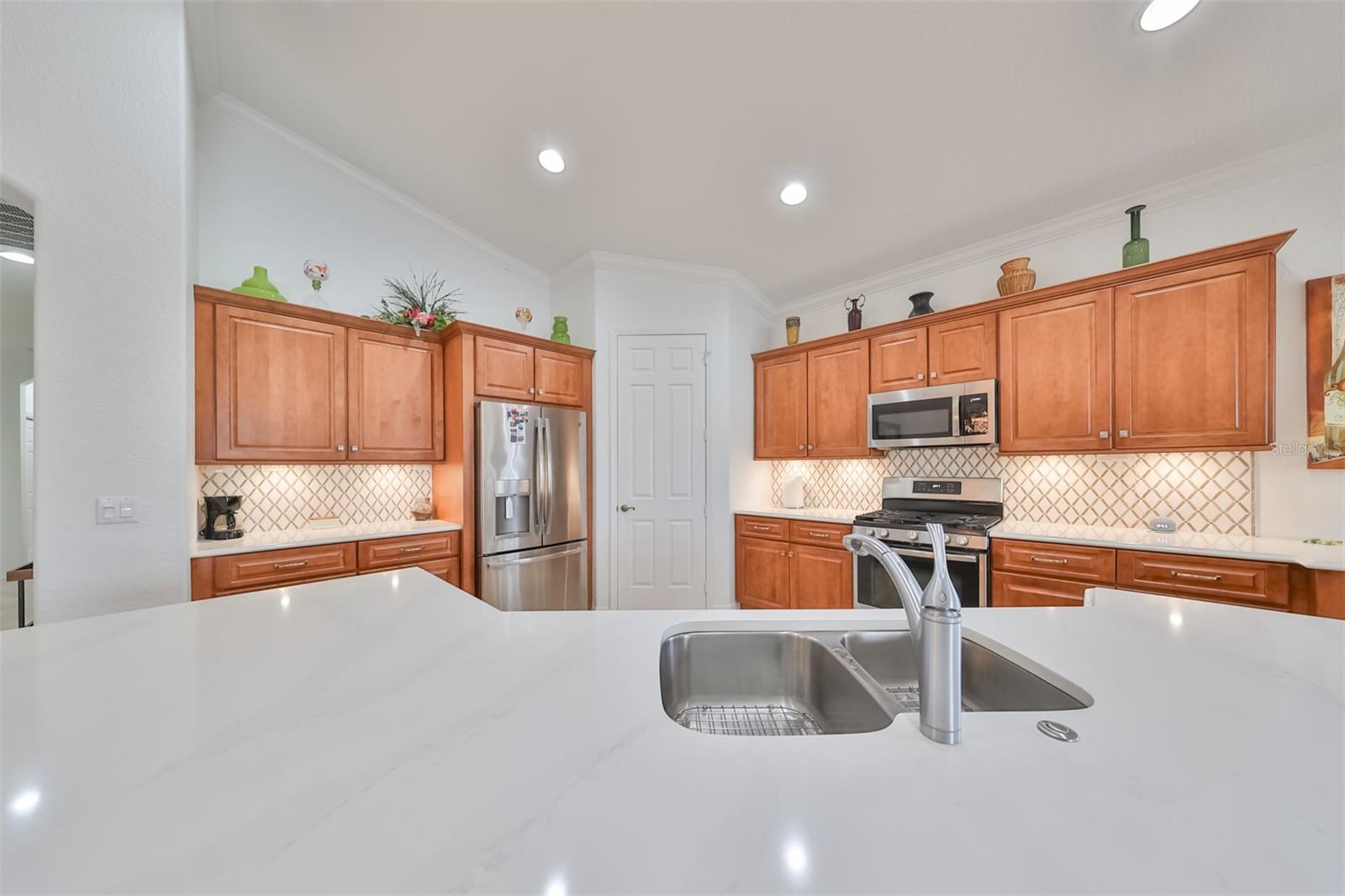 This kitchen boasts of newer, high-end stainless steel appliances, natural gas range and a large walk in pantry.