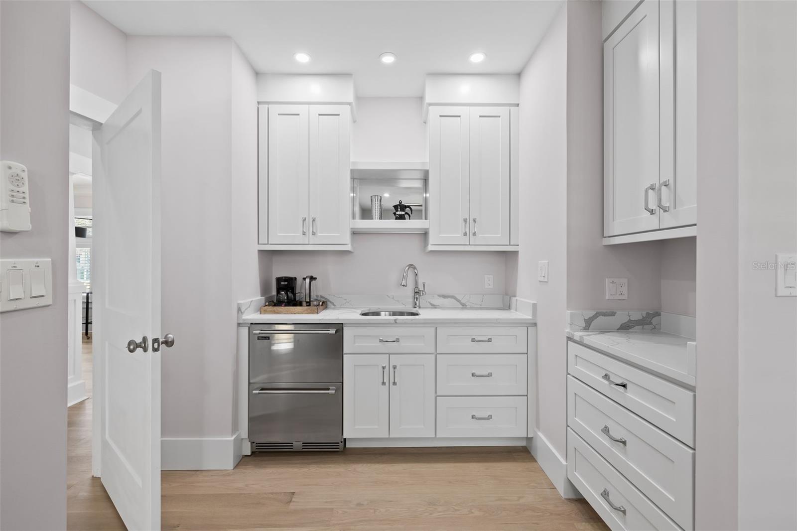 Coffee bar, small refrigerator, sink and lots of storage space with roll-outs drawers.