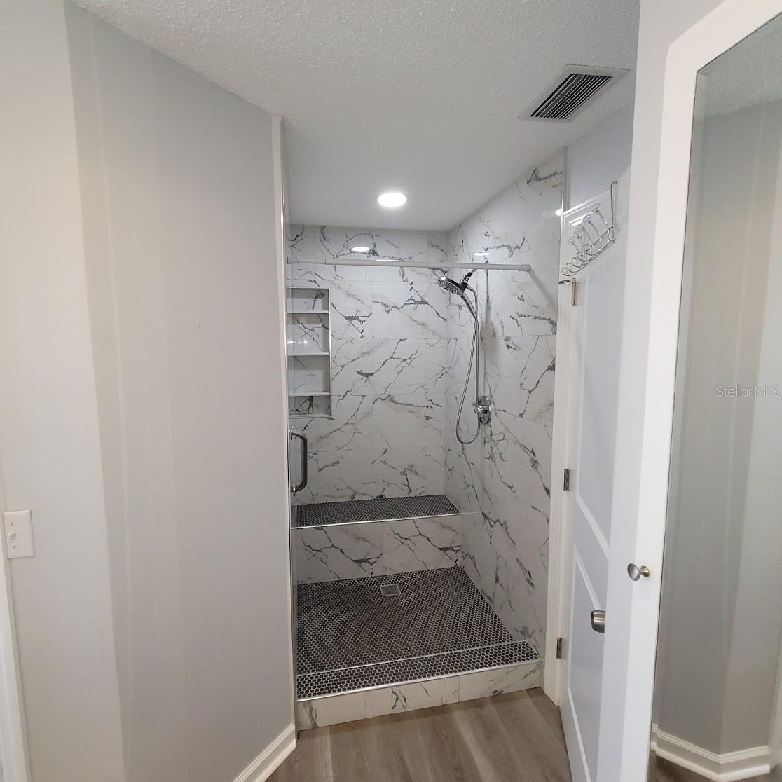 A walk in shower with a bench to be enjoyed.