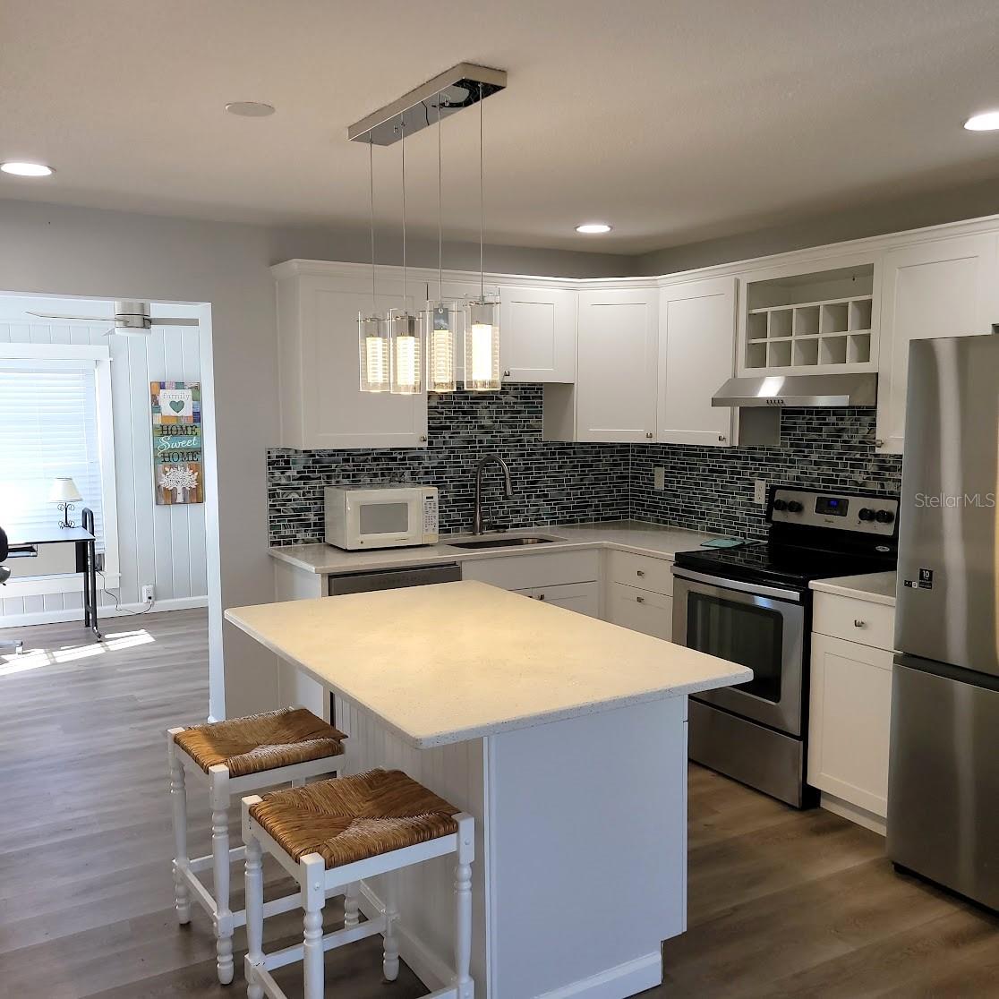 The kitchen is welcoming and offers a lot of counter space and cabinets. The island offers space for baking, rolling out pasta, or even working puzzles!