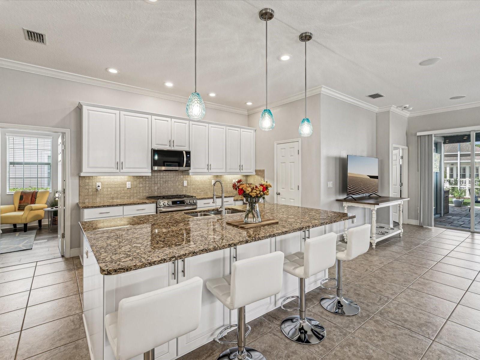 Pendant lighting accent the oversized kitchen island that comfortably seats four.