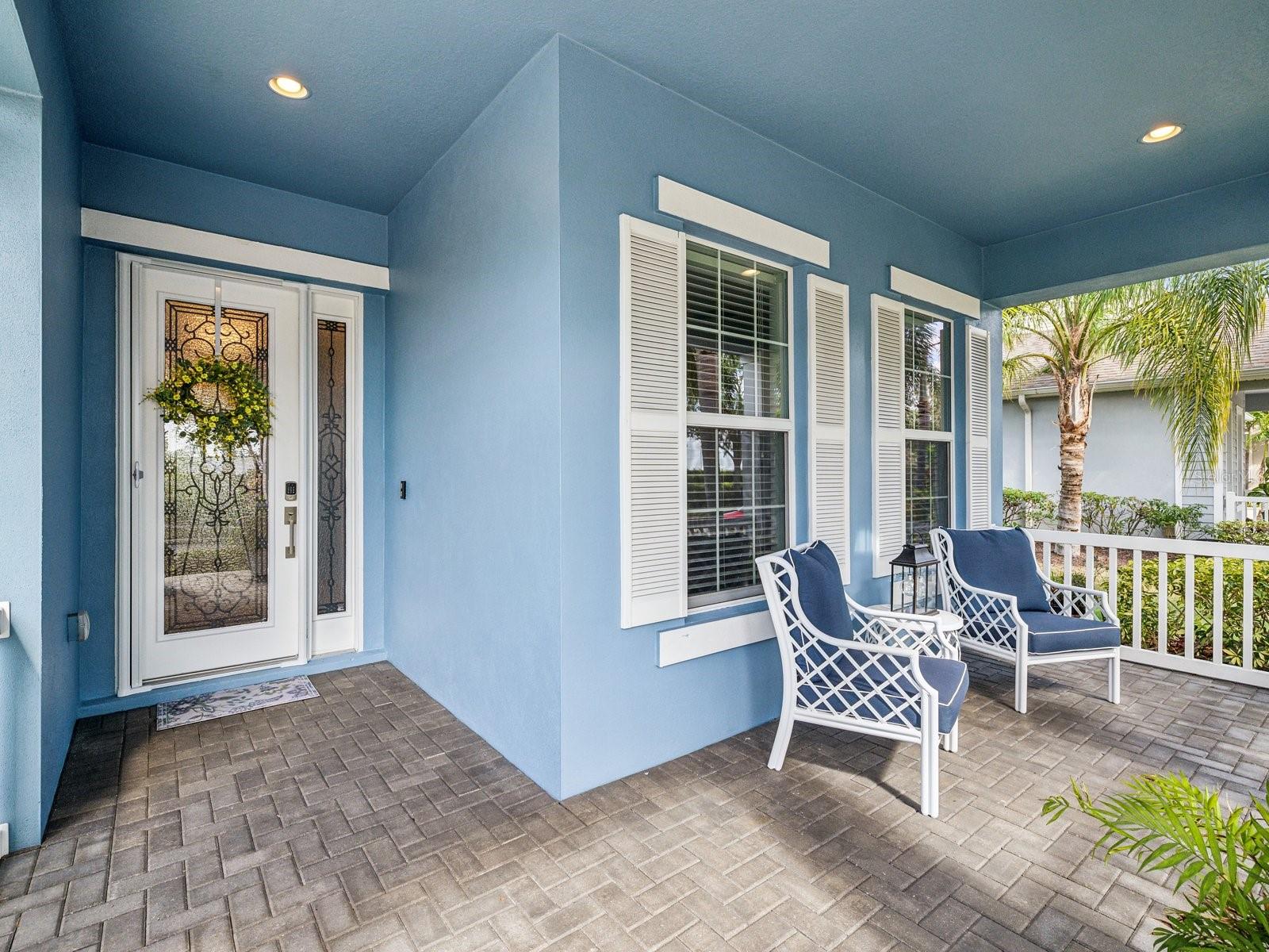 Pavers accentuate the porch leading to the beveled glass front door with a matching right sidelight.