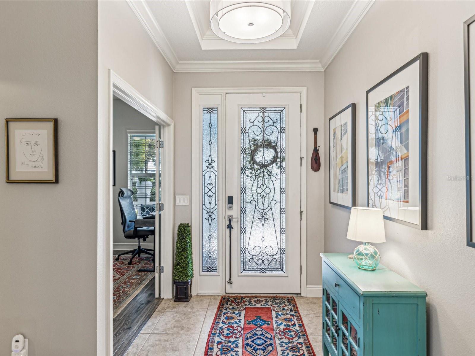 The welcoming entry, with a tray ceiling and a decorative light fixture, offers a glimpse into the elegance the rest of the home has to offer.