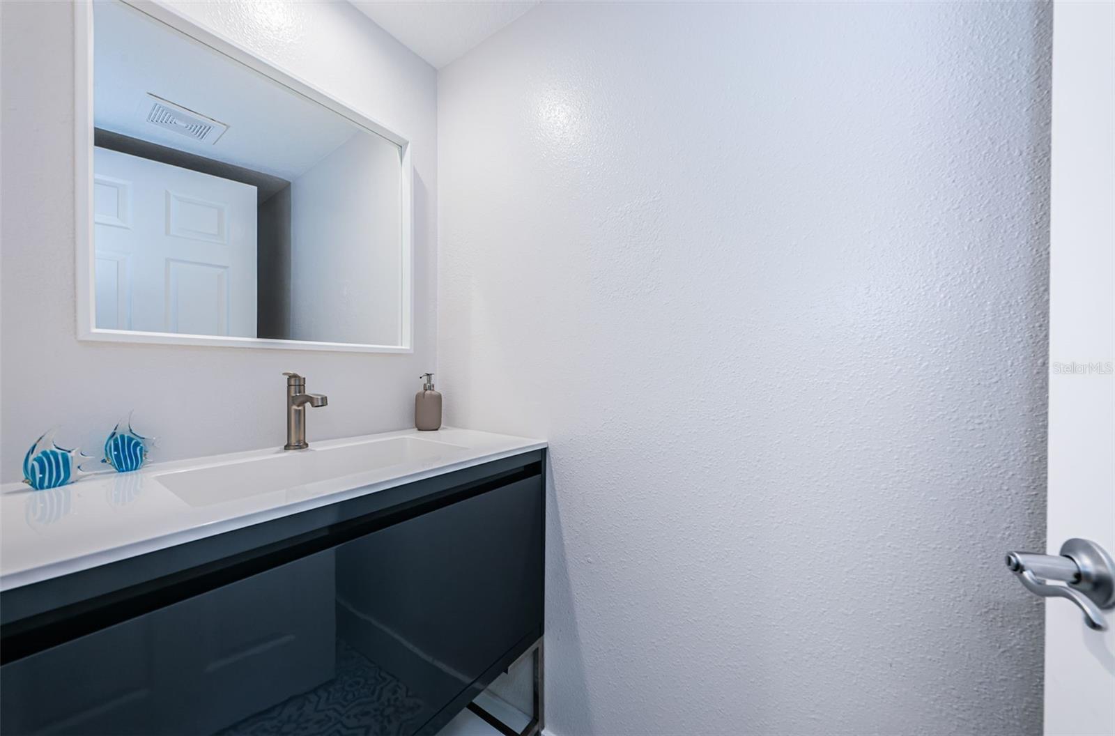 Remodeled half bath downstairs with luxury vanity sink and pull out storage.