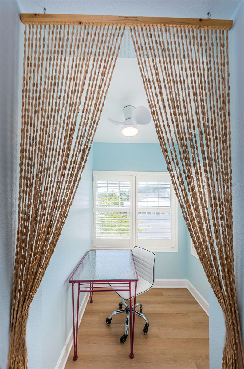 Office nook with beaded curtain for separation.