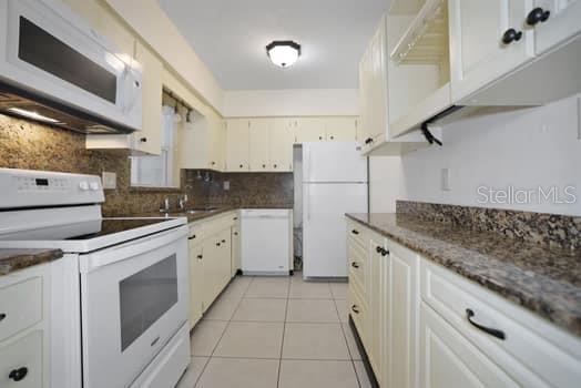 Galley kitchen with dishwasher and granite countertops