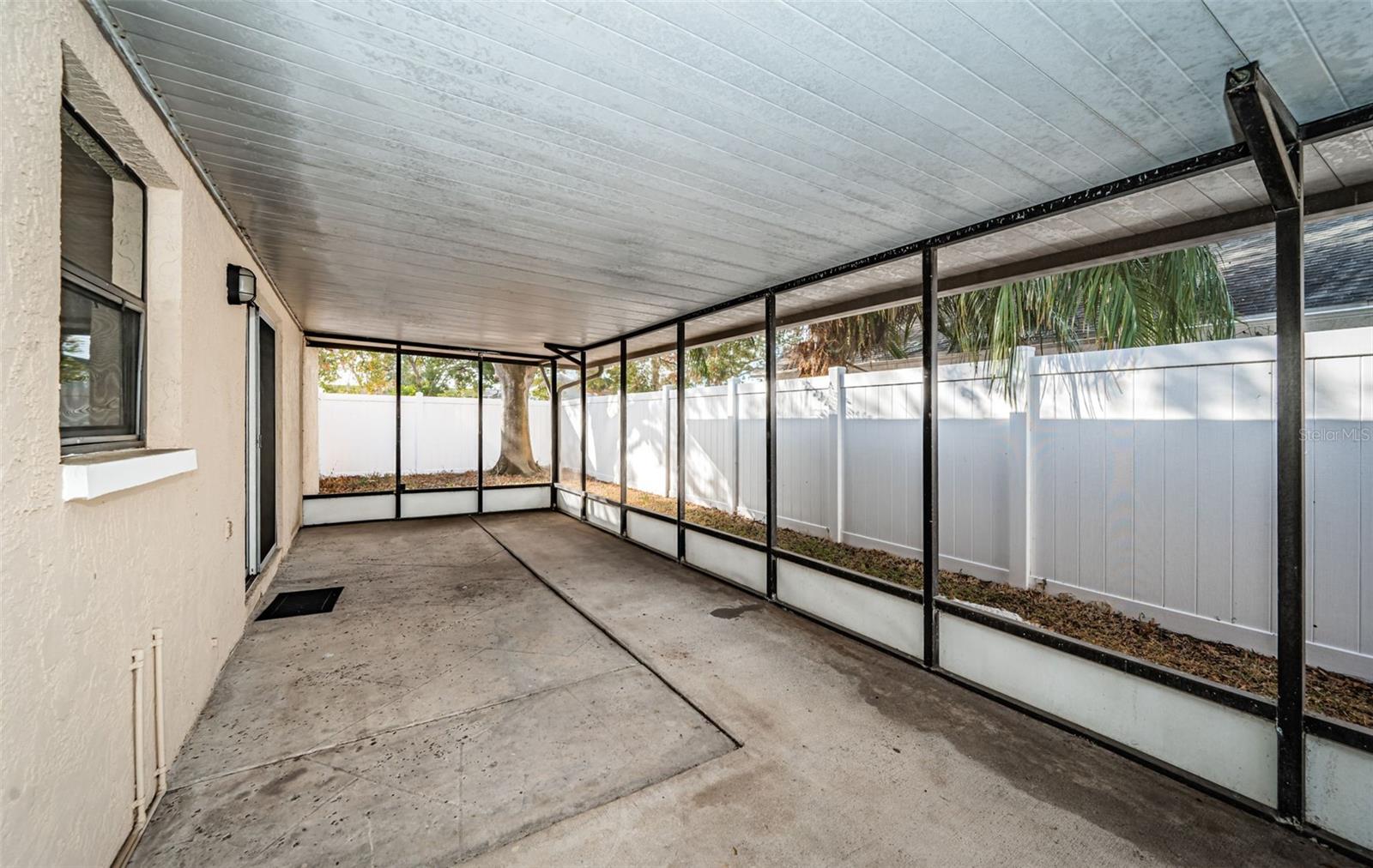 View of covered back patio and newer vinyl fence