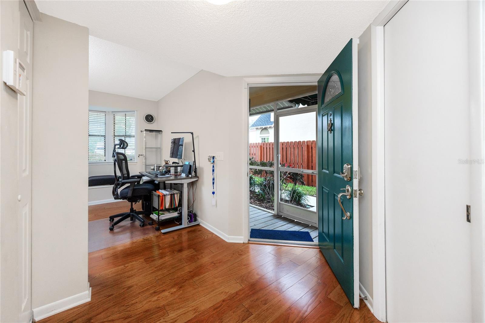 Entryway with view into the front room currently being used as an office.