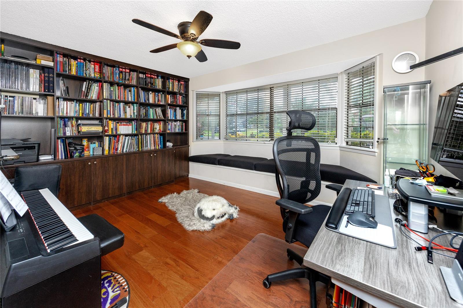 Flex/bonus room that can be used for multiple uses. Custom built in bookcases, a window seat with storage, and wood floors add to the charm of this space.