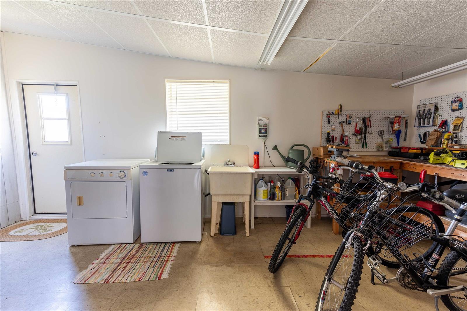 Indoor laundry area include workshop and plenty of storage.