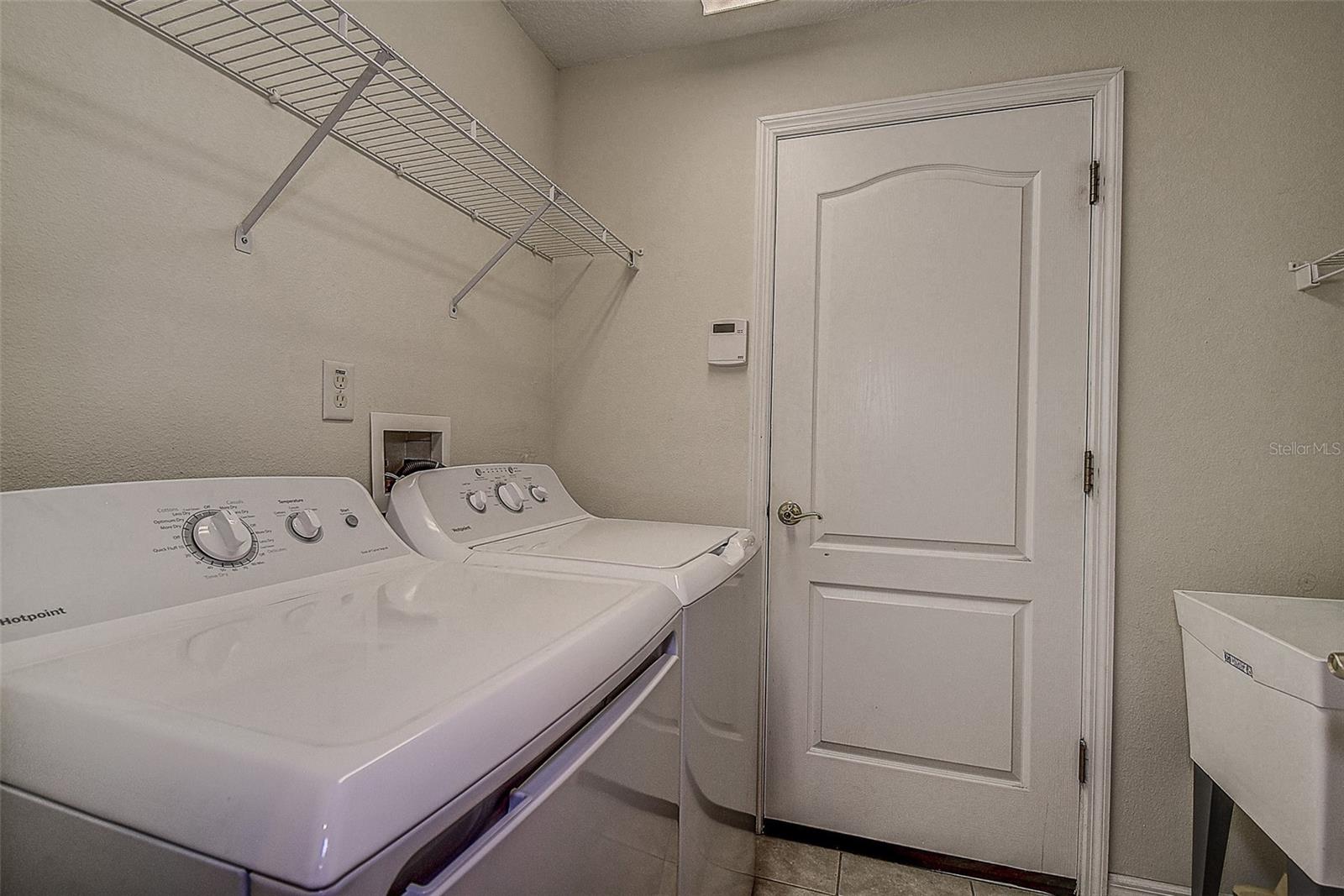 Inside laundry room with laundry tub, washer and dryer